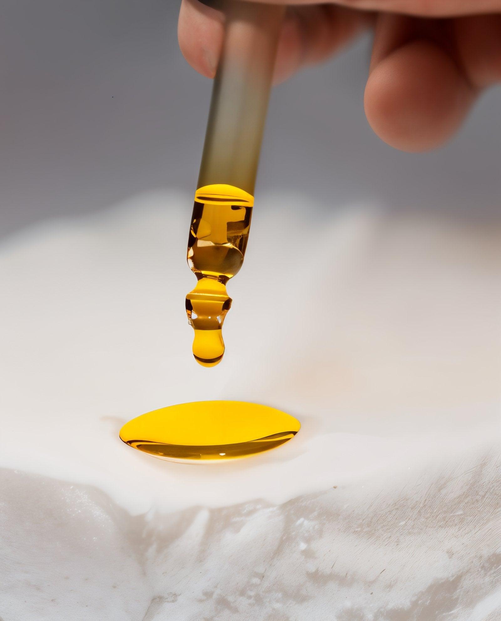 Eclat Soin Multi-Purpose Facial Oil being dripped from a dropper onto a white surface